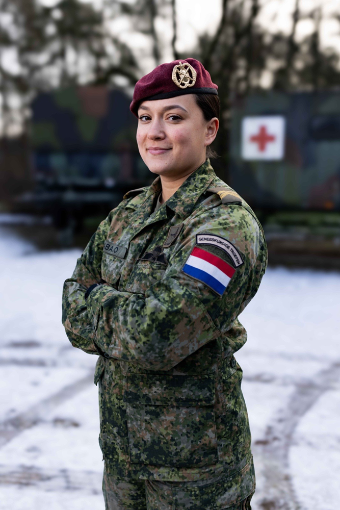 De coach poseert in legeruniform.